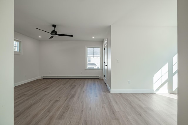 unfurnished room with ceiling fan, a baseboard radiator, and light hardwood / wood-style floors