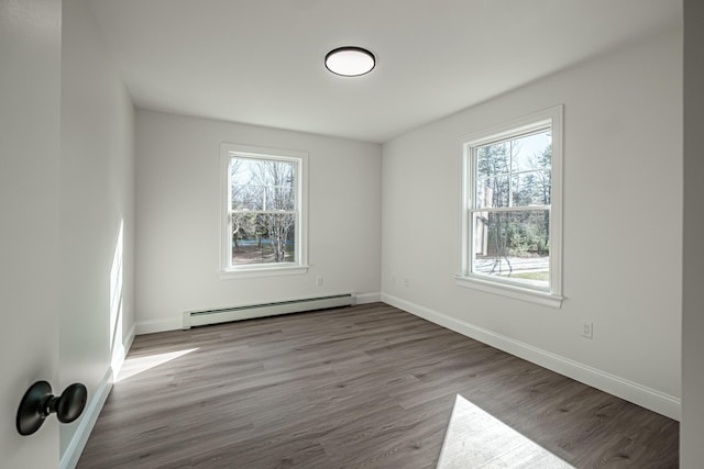 spare room with baseboard heating and light wood-type flooring