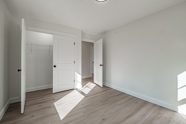 unfurnished bedroom featuring light wood-type flooring and a closet