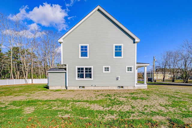 rear view of property featuring a lawn