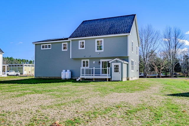 rear view of house featuring a lawn and a wooden deck