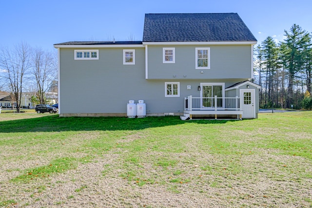 back of property with a yard and a wooden deck