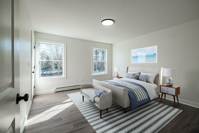 bedroom with a baseboard heating unit and light wood-type flooring