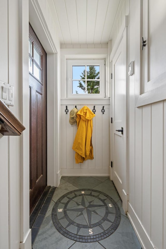 mudroom with dark tile patterned flooring and a wealth of natural light