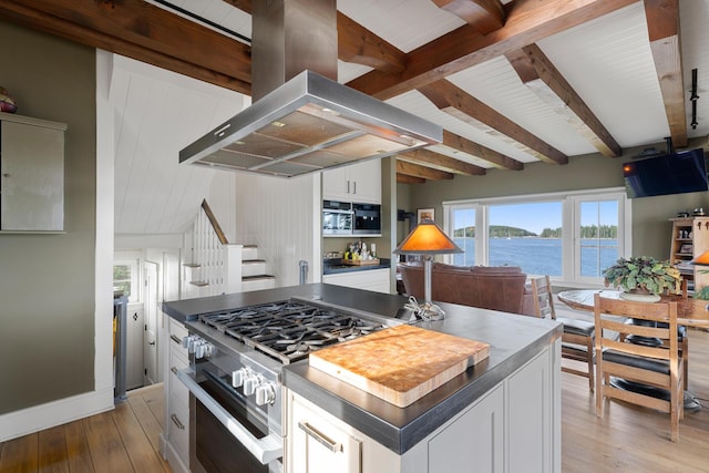 kitchen with white cabinets, island range hood, a center island, and stainless steel gas range oven