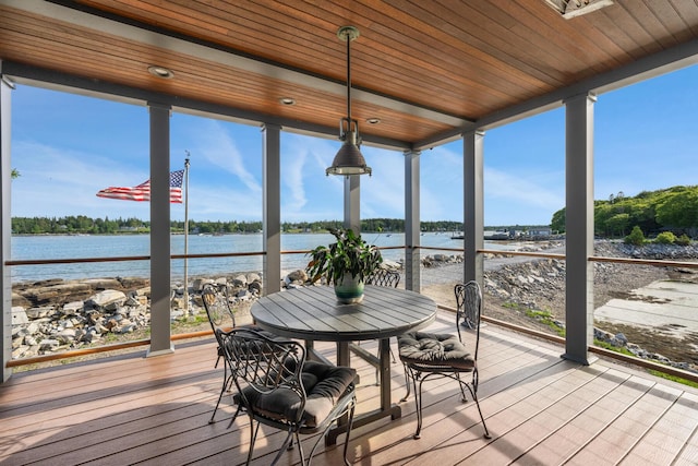 sunroom featuring wooden ceiling, plenty of natural light, and a water view