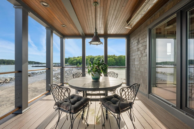 sunroom with a healthy amount of sunlight, wood ceiling, and a water view