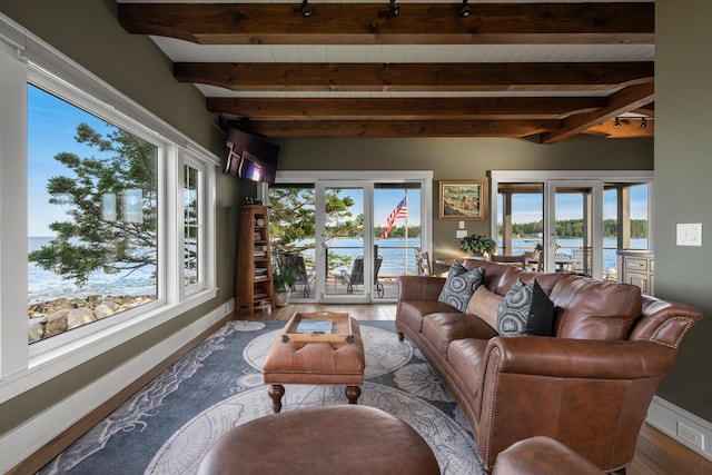 living room with french doors, lofted ceiling with beams, and wood-type flooring