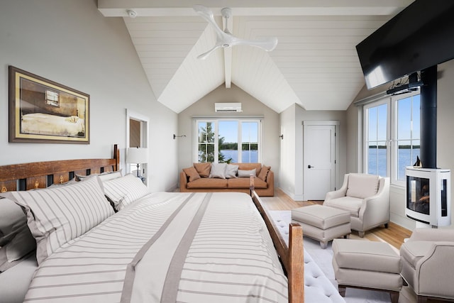 bedroom featuring lofted ceiling with beams, a water view, and light hardwood / wood-style flooring