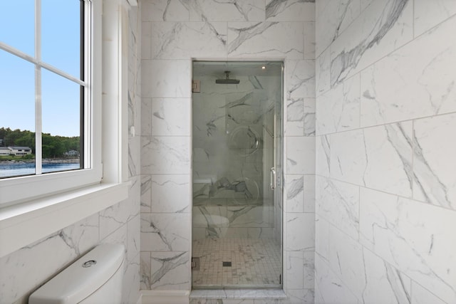 bathroom featuring toilet and a shower with door