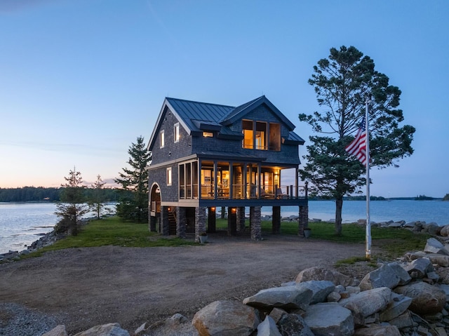 back house at dusk with a water view