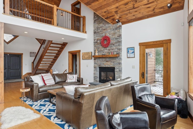 living room with high vaulted ceiling, wooden ceiling, a fireplace, and light wood-type flooring