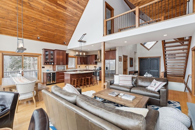 living room with a notable chandelier, wood ceiling, light wood-type flooring, and high vaulted ceiling