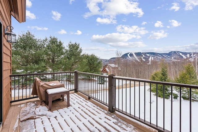 snow covered deck with a mountain view