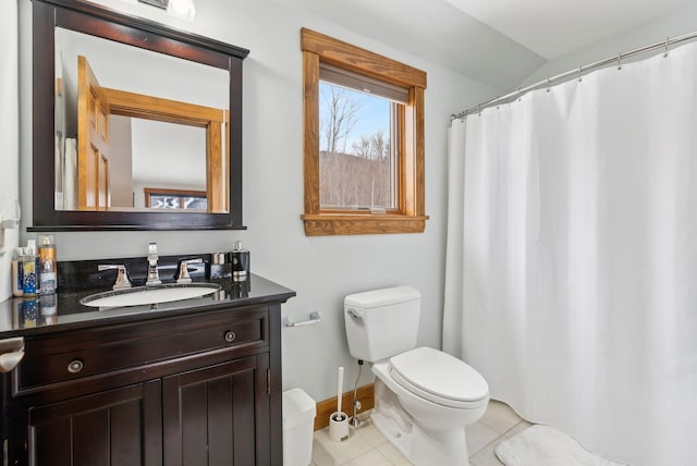 bathroom featuring toilet, vanity, lofted ceiling, and tile patterned flooring