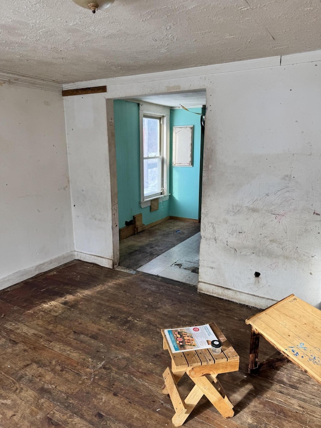 spare room with a textured ceiling and dark wood-type flooring