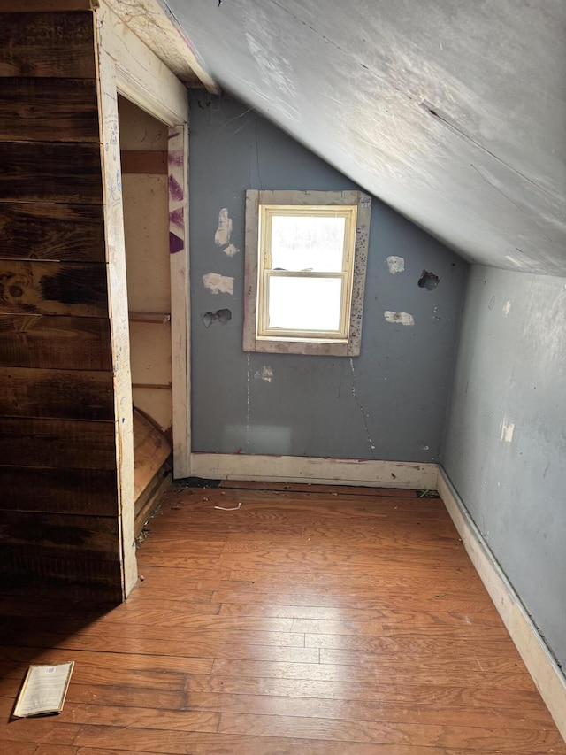 additional living space featuring lofted ceiling and wood-type flooring