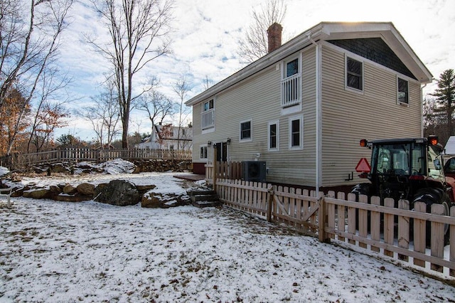 snow covered property featuring central air condition unit