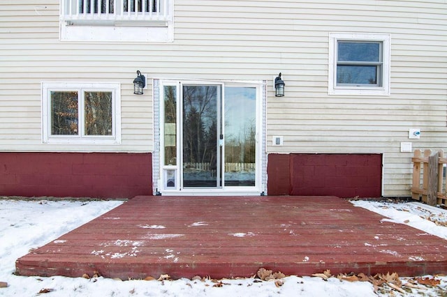 snow covered property entrance featuring a deck