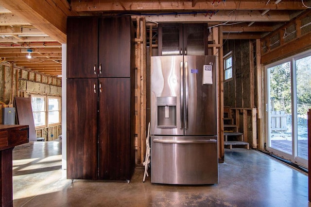 kitchen featuring stainless steel refrigerator with ice dispenser, concrete floors, and dark brown cabinets