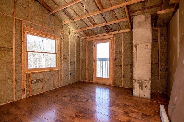 misc room featuring dark wood-type flooring, a wealth of natural light, a baseboard heating unit, and lofted ceiling