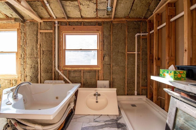 bathroom with a healthy amount of sunlight, sink, and a bath