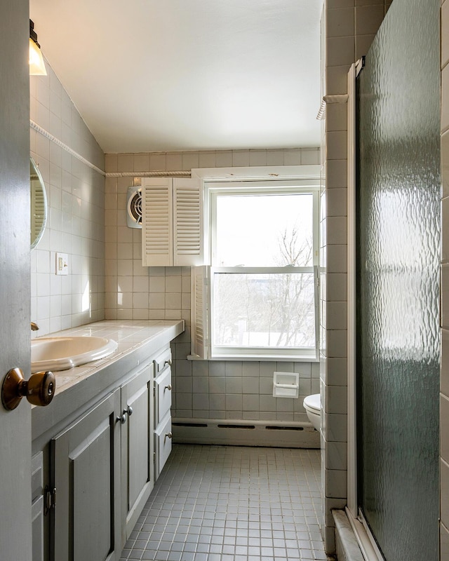 bathroom featuring toilet, tile walls, baseboard heating, tile patterned floors, and vanity