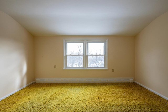 empty room with a baseboard heating unit and carpet flooring