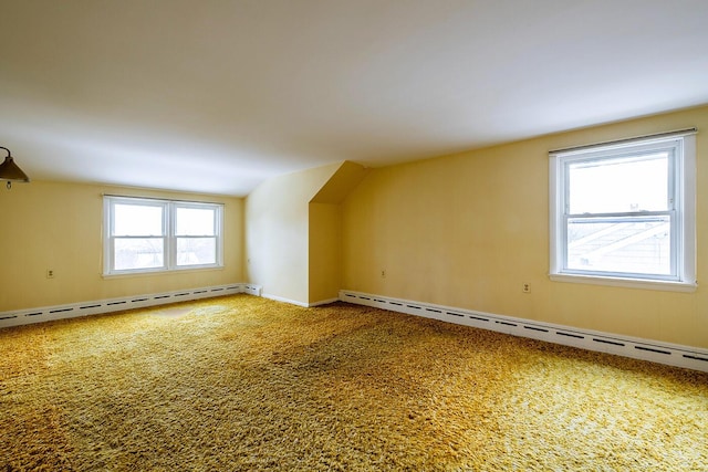 bonus room with carpet flooring, baseboard heating, and a healthy amount of sunlight