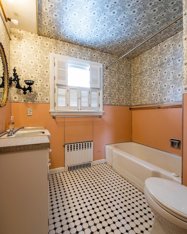 bathroom featuring tile patterned flooring, toilet, vanity, and radiator