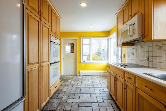 kitchen featuring white appliances, backsplash, and a baseboard heating unit