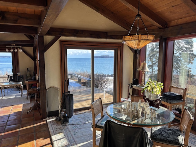 dining room featuring a water view, plenty of natural light, beamed ceiling, and wooden ceiling