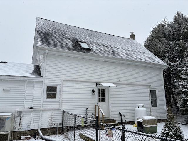 snow covered back of property with ac unit