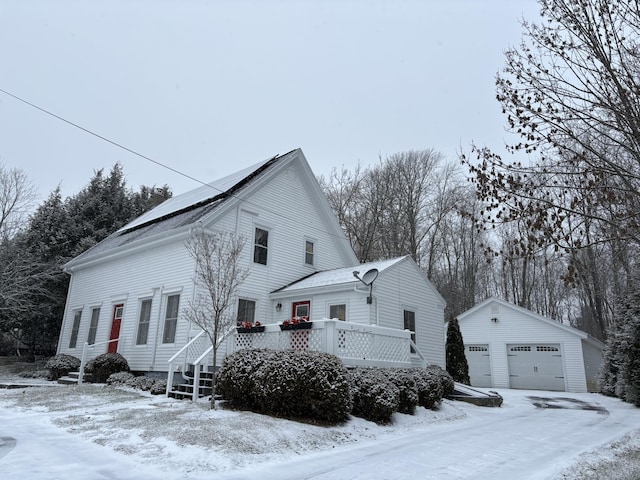 view of front of house with a garage, a wooden deck, and an outdoor structure