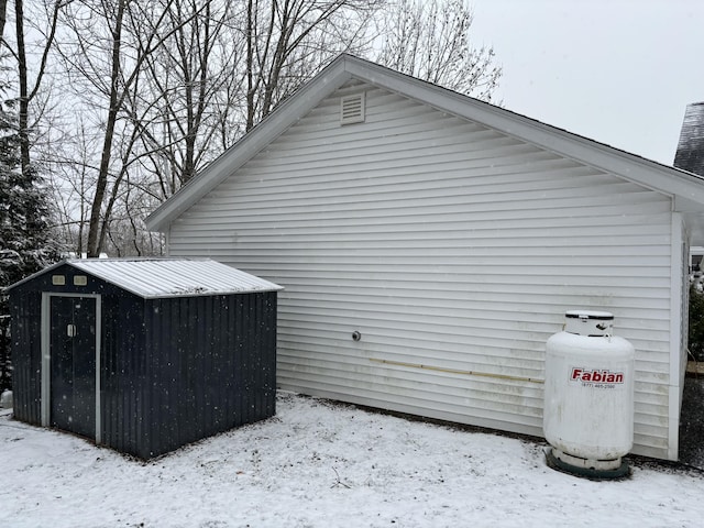 snow covered property with a storage unit