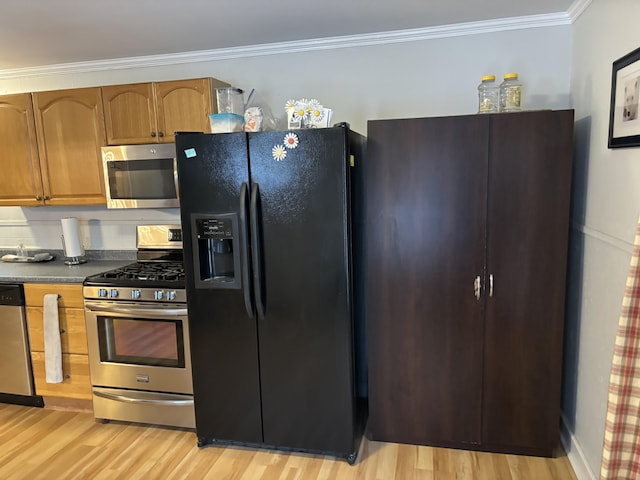 kitchen featuring stainless steel appliances, crown molding, and light hardwood / wood-style floors