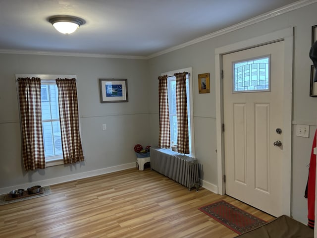 entrance foyer with radiator, crown molding, and light hardwood / wood-style floors