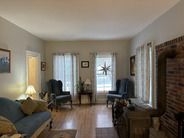 sitting room with a wood stove and hardwood / wood-style flooring