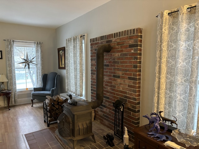 sitting room featuring dark wood-type flooring and a wood stove