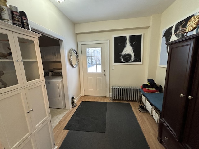 mudroom with washer / clothes dryer, radiator heating unit, and light hardwood / wood-style floors