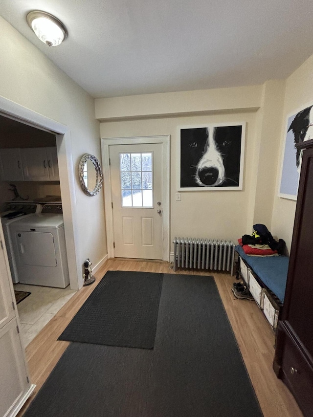 foyer featuring radiator, light wood-type flooring, and washer / dryer