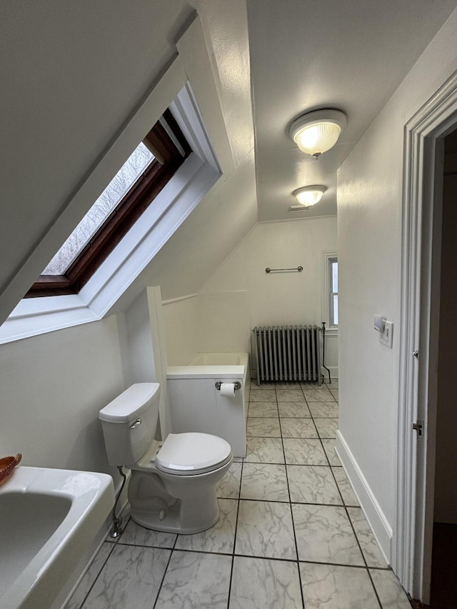 bathroom featuring toilet, a skylight, and radiator heating unit