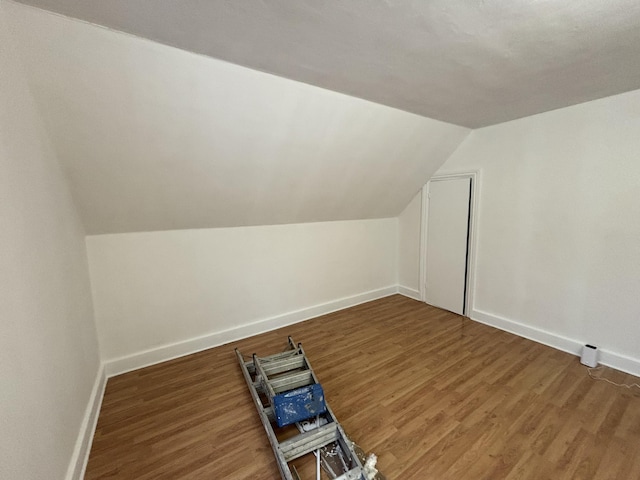 bonus room with dark hardwood / wood-style floors and lofted ceiling