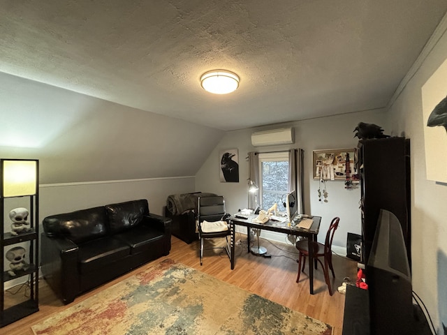 office space with lofted ceiling, an AC wall unit, a textured ceiling, and wood-type flooring