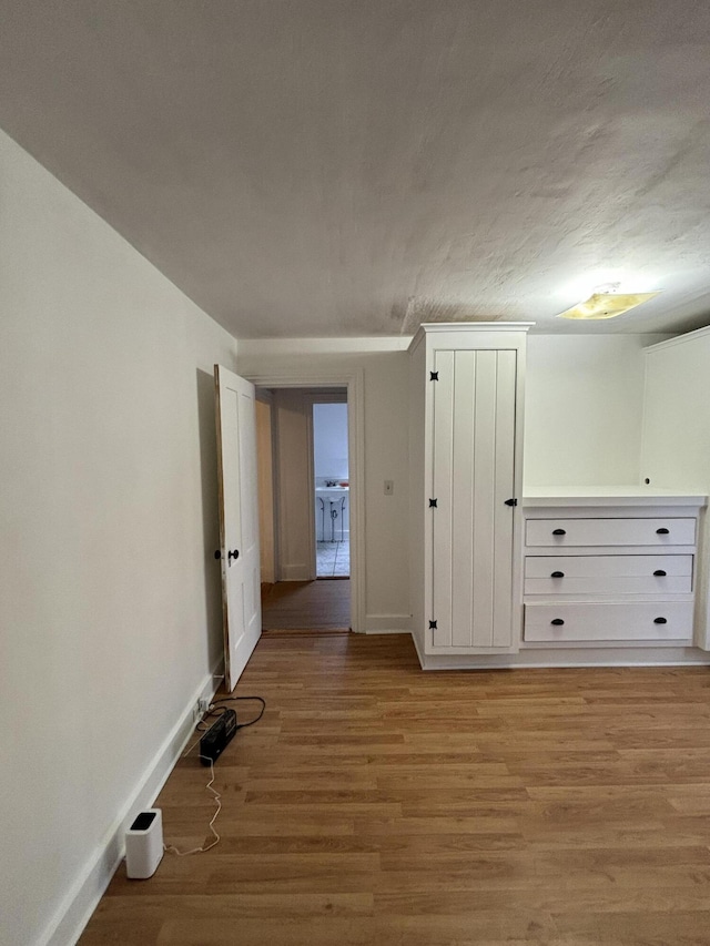 unfurnished room featuring a textured ceiling and light hardwood / wood-style flooring