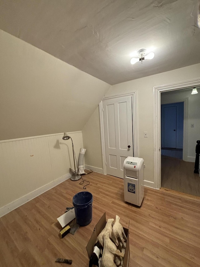 bonus room with vaulted ceiling and light hardwood / wood-style flooring