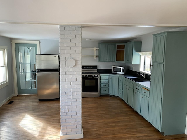 kitchen featuring sink, green cabinetry, dark hardwood / wood-style floors, and appliances with stainless steel finishes