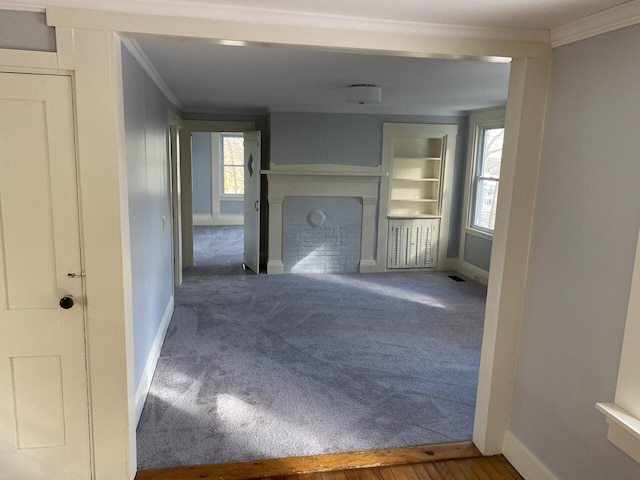 unfurnished living room featuring carpet flooring, a brick fireplace, and ornamental molding