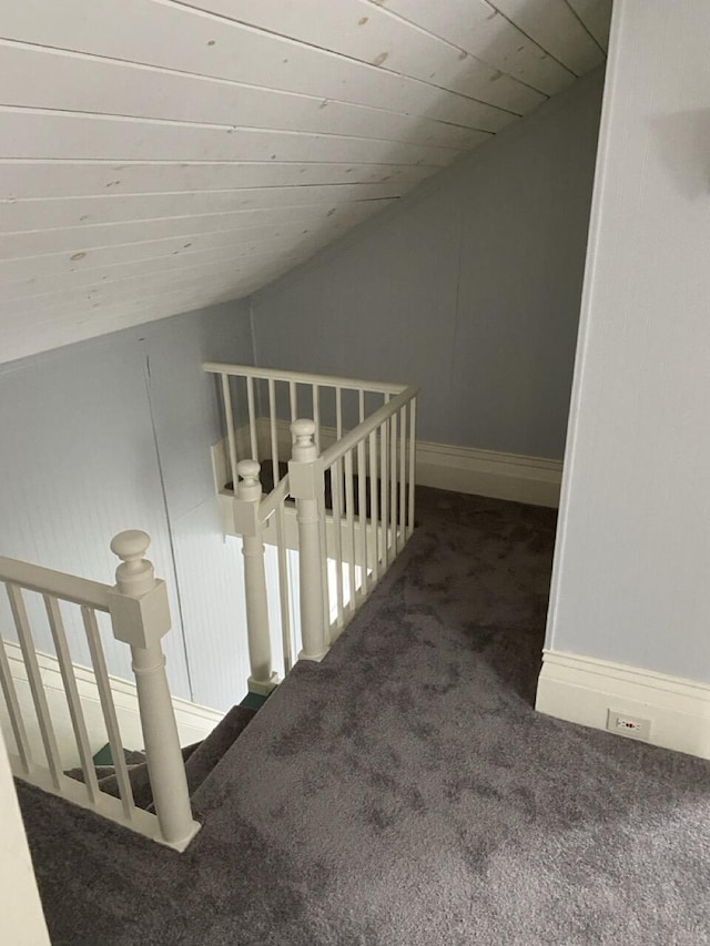 stairway with wooden ceiling, lofted ceiling, and carpet flooring