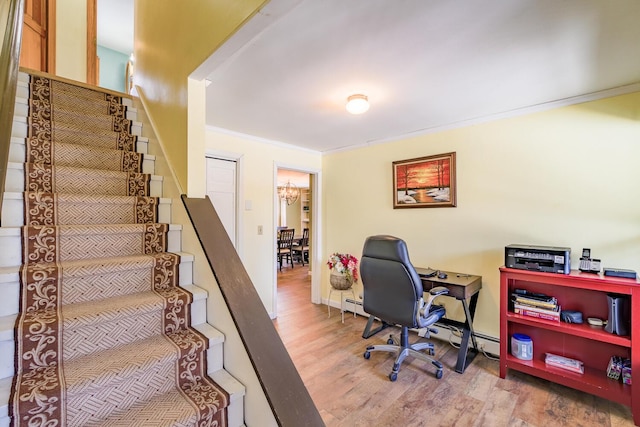 office with wood-type flooring, an inviting chandelier, and crown molding